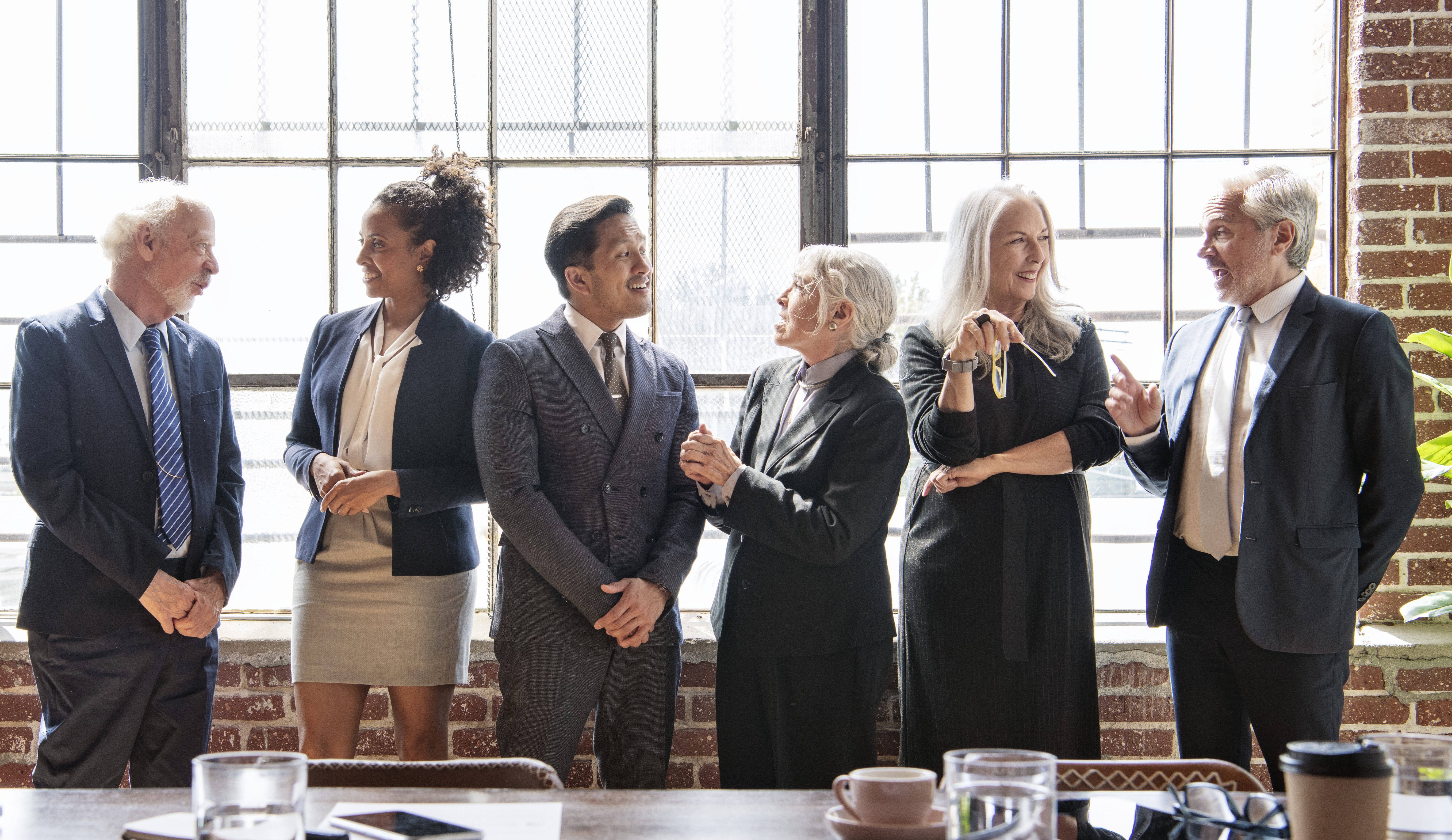 professionals gather by window in a bright office